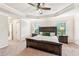 Main bedroom with a tray ceiling, fan, carpeting, windows and a large bed at 6825 Rambling Vale, Cumming, GA 30028