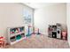 playroom with carpet flooring, window, toy shelving and a small play kitchen at 6825 Rambling Vale, Cumming, GA 30028