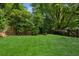 Green backyard featuring a large, well-maintained lawn and mature trees providing privacy at 747 Channing Nw Dr, Atlanta, GA 30318