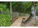 Backyard features a wooden deck with a wooden walkway, surrounded by trees and dense foliage at 747 Channing Nw Dr, Atlanta, GA 30318
