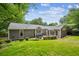 Expansive backyard with a lush lawn, patio, and landscaping surrounding the house and fenced perimeter at 747 Channing Nw Dr, Atlanta, GA 30318