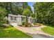 Charming home with gray siding, black shutters, well-manicured landscaping, and a circular driveway at 747 Channing Nw Dr, Atlanta, GA 30318