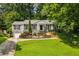 Charming home with a well-manicured front lawn, driveway, and lush landscaping with mature trees at 747 Channing Nw Dr, Atlanta, GA 30318
