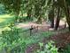 Fenced in playground area with green play equipment, picnic tables, and mature trees behind a black metal fence at 747 Channing Nw Dr, Atlanta, GA 30318