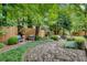 Relaxing backyard featuring a stone path, manicured bushes, and a wooded perimeter at 1676 Grove Park Way, Decatur, GA 30033