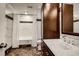Well-lit bathroom with marble floors, a marbled-wall shower/tub, and dark-stained cabinets at 1676 Grove Park Way, Decatur, GA 30033
