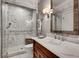 Bright bathroom featuring a glass shower with marble tile surround and wood vanity with marble countertops at 1676 Grove Park Way, Decatur, GA 30033