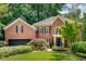 Elegant brick home showcasing manicured lawn, mature landscaping, and attached garage at 1676 Grove Park Way, Decatur, GA 30033