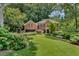 Charming brick home with lush landscaping, a well-manicured lawn, and mature trees at 1676 Grove Park Way, Decatur, GA 30033