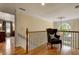 Bright hallway with wood floors, decorative railing, and comfortable accent chair at 1676 Grove Park Way, Decatur, GA 30033