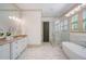 Luxurious bathroom featuring a soaking tub, glass-enclosed shower, and elegant vanity at 175 Centennial Trce, Roswell, GA 30076