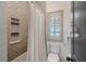 Bathroom with tile shower and tub, window with shutters, and white toilet at 175 Centennial Trce, Roswell, GA 30076