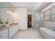 Luxurious bathroom with a freestanding tub, walk-in glass shower, dual vanity, and plantation shutters at 175 Centennial Trce, Roswell, GA 30076