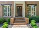 Elegant home entrance with brick steps, manicured bushes, and a grand double door, radiating sophistication at 175 Centennial Trce, Roswell, GA 30076