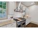 Updated kitchen with granite counters, professional range, white cabinetry, and stainless steel hood at 175 Centennial Trce, Roswell, GA 30076