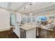 Bright, open kitchen featuring an island with granite countertops, stainless appliances, and open view to the living area at 175 Centennial Trce, Roswell, GA 30076