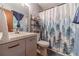 Stylish bathroom featuring modern vanity, toilet, and shower with nature-themed curtain at 2645 Holly Berry Trl, Snellville, GA 30039
