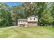 Charming home with stone facade, stairs, green lawn, and mature trees on a sunny day at 2645 Holly Berry Trl, Snellville, GA 30039