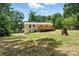 View of the backyard featuring a raised wooden deck, lush trees, and ample green space at 3013 Michael Sw Dr, Marietta, GA 30060