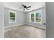 Bright bedroom featuring a ceiling fan, light gray walls, wood-look flooring, and double windows at 3013 Michael Sw Dr, Marietta, GA 30060