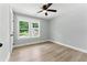 Bright bedroom featuring a ceiling fan, light gray walls, wood-look flooring, and double windows at 3013 Michael Sw Dr, Marietta, GA 30060