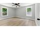 Bright bedroom featuring a ceiling fan, light gray walls, wood-look flooring, and double windows at 3013 Michael Sw Dr, Marietta, GA 30060