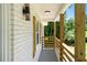 Inviting front porch with wood railing, stylish light fixture, and white brick exterior at 3013 Michael Sw Dr, Marietta, GA 30060