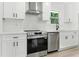 Modern kitchen featuring stainless steel appliances, white cabinets, and a stylish range hood at 3013 Michael Sw Dr, Marietta, GA 30060