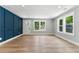 Spacious living room featuring a dark blue accent wall, wood-look flooring, and double windows at 3013 Michael Sw Dr, Marietta, GA 30060