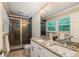 A modern bathroom features double sinks, granite countertop, and glass enclosed shower at 3597 Embry Cir, Atlanta, GA 30341
