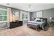 Comfortable bedroom with neutral tones, carpet, fan, artwork, and multiple windows for natural light at 3597 Embry Cir, Atlanta, GA 30341
