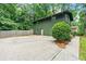 Green brick two-story home featuring a spacious concrete parking pad and a charming, well-maintained yard at 3597 Embry Cir, Atlanta, GA 30341