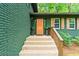 Close up of the home's front porch, featuring a wooden door and brick steps with wooden railing at 3597 Embry Cir, Atlanta, GA 30341