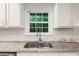 Close-up of kitchen sink, subway tile backsplash, and granite countertops in a bright setting at 3597 Embry Cir, Atlanta, GA 30341