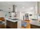 The open kitchen features stainless appliances, an island with cooktop, granite countertops, and wood floors at 3597 Embry Cir, Atlanta, GA 30341