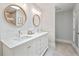 Bright bathroom featuring double vanity with round mirrors, quartz counters, and modern fixtures at 4016 Dover Ave, Alpharetta, GA 30009