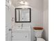 Clean bathroom featuring a sleek black framed mirror, white vanity, and standard toilet at 4016 Dover Ave, Alpharetta, GA 30009