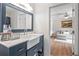Stylish bathroom with white farmhouse sink, blue vanity, and view to sitting room at 4016 Dover Ave, Alpharetta, GA 30009