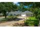 Pleasant scene of a one-story home and mature trees creating a beautiful, shaded yard at 4016 Dover Ave, Alpharetta, GA 30009