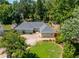 Inviting one-story home featuring a circular driveway, manicured lawn, and charming landscaping at 4016 Dover Ave, Alpharetta, GA 30009