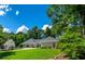 View of the home's well-maintained lawn, established trees, and circular driveway on a sunny day at 4016 Dover Ave, Alpharetta, GA 30009
