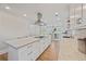 Open concept kitchen with a large island, stainless steel range hood, and white cabinetry at 4016 Dover Ave, Alpharetta, GA 30009