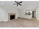 Open-concept living room with fireplace, light wood floors, and open access to the kitchen at 404 Hawkstone Way, Alpharetta, GA 30022