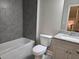 Bathroom features a granite countertop, shower-tub combo, and gray tiled walls at 5715 Rocky Falls Drive, Suwanee, GA 30024