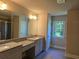 Bathroom featuring a double sink vanity, granite countertops, and a large mirror at 5715 Rocky Falls Drive, Suwanee, GA 30024