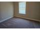 Cozy bedroom with plush carpet, neutral walls, and a window overlooking the yard at 5715 Rocky Falls Drive, Suwanee, GA 30024
