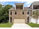 Charming brick townhome with a two-car garage and a balcony on the second floor at 5715 Rocky Falls Drive, Suwanee, GA 30024