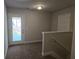Second floor hallway featuring a stairway and access to an outdoor balcony at 5715 Rocky Falls Drive, Suwanee, GA 30024