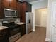 Modern kitchen with stainless steel appliances, granite countertops, and dark wood cabinets at 5715 Rocky Falls Drive, Suwanee, GA 30024