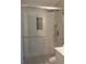 A remodeled bathroom features a frameless shower with rainfall shower head and marble style tile at 1380 Ashbrook Dr, Lawrenceville, GA 30043